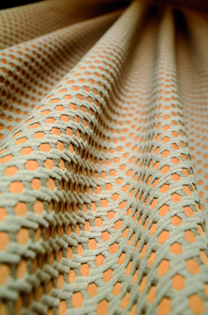 an orange and white fabric with small circles on the top, as if it were woven