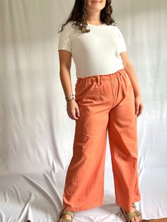 These pants were made from a thrifted, peachy/light orange fabric. They have an elastic waistband, belt loops, and side pockets. The pants look great longer to the ankle or cropped, and the comfy soft fabric allows for movement. They are one of a kind in the peach colored fabric, and only made in size M. Pants Measurements: Waist: 30" Hips: 40" If you have a sizing or fit question, don't hesitate to send me a message! Orange Cotton Bottoms For Spring, Spring Orange Cotton Bottoms, Orange Relaxed Fit Bottoms With Elastic Waistband, Relaxed Fit Orange Bottoms With Elastic Waistband, Orange Relaxed Fit Pants With Pockets, Orange Straight Leg Cotton Pants, Orange Bottoms With Elastic Waistband And Relaxed Fit, Relaxed Fit Orange Pants With Pockets, Orange Straight Leg Bottoms For Summer