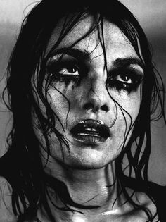 a black and white photo of a woman with wet hair on her head, wearing makeup