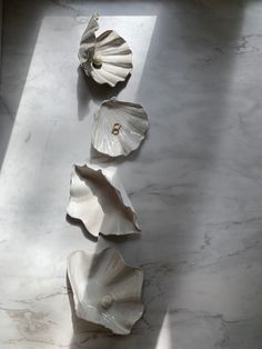 three seashells sitting on top of a white marble counter next to each other