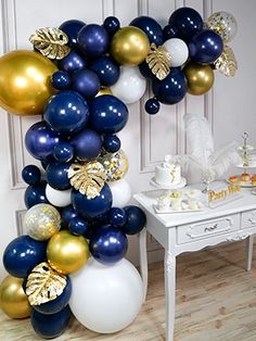 the balloon arch is decorated with gold, white and blue balloons