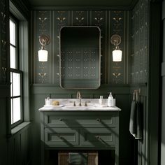 a bathroom with dark green walls and white counter tops, along with a large mirror above the sink