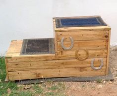 a wooden box with two metal handles on the top and bottom, sitting in front of a white wall