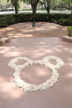 an olympic symbol made out of flowers in the middle of a walkway at a park