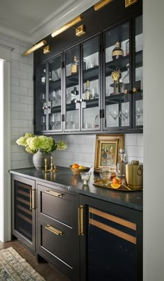 a kitchen with black cabinets and gold trim