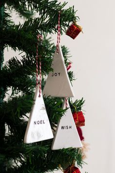 three ornaments hanging from a christmas tree with the words noel and wish written on them