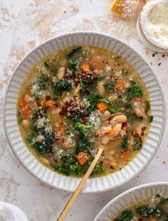 two white bowls filled with soup and vegetables