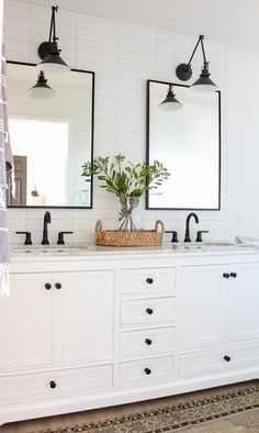 a bathroom with double sinks and two mirrors on the wall next to eachother