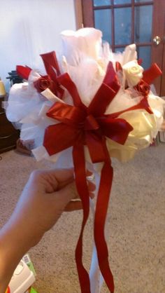 someone is holding a bouquet with white and red flowers