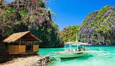 a boat is docked in the clear blue water near an island with trees and cliffs