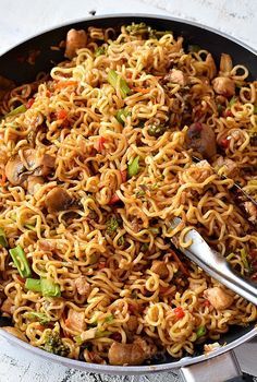 a pan filled with noodles and vegetables on top of a table