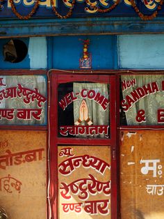 an old building with many signs on the front and side windows that say life is come, sandhi & bhaji