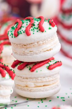 a stack of cookies covered in white frosting and sprinkles on top of each other