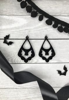 Dress up your spooky outfit with these bat dangle earrings. Laser cut black acrylic, made and designed by The Sketchy Pumpkin. Two fish hooks options:-Stainless Steal -Plastic (for those who want to prevent any allergic reaction that typically comes from metal). Each come with rubber stoppers to prevent slipping. Measurements: Full dangle length from earlobe: 3"Actual Earring size: 2.5" H x 1.5 W" - - - - - - - - - Tiktok: @thesketchypumpkin Instagram: Art: @thesketchypumpkin Shop: @thesketchypu