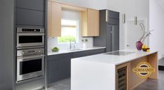 a modern kitchen with stainless steel appliances and white counter tops