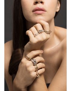 a woman wearing three different rings on her arm and one is looking at the camera