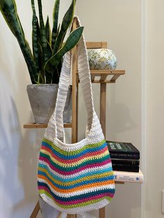 a crocheted bag sitting on top of a table next to a potted plant