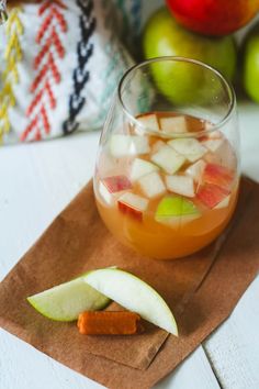 an apple cider with ice and sliced apples