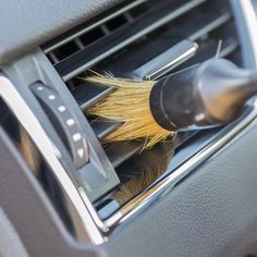 a car air conditioner with a brush in it's ventilator that is being cleaned