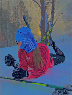 a woman sitting in the snow with skis on her feet