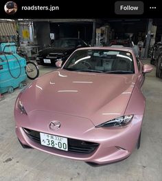 a pink sports car parked in a garage