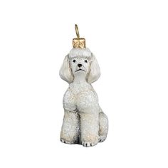 a white poodle ornament with a gold top hat on it's head