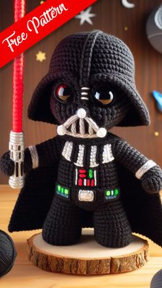 a crocheted darth vader toy with a red light saber in his hand