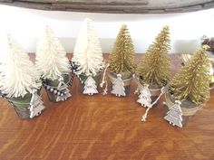 small christmas trees in tin cans on a table