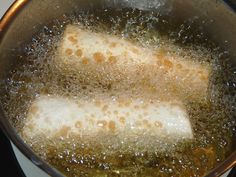 two pieces of fish are being cooked in oil