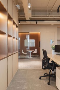 an empty office with desks and chairs in the center, along with open shelving