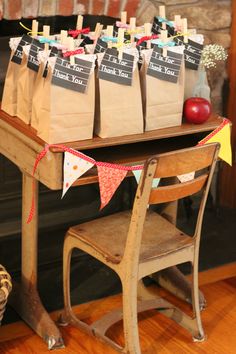 there is a desk with bags on it and an apple in the back ground, next to a fireplace