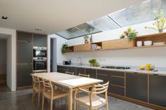 a modern kitchen with wooden cabinets and white counter tops, along with an island in the middle