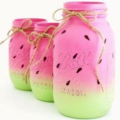 three pink and green mason jars with writing on them