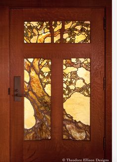 a wooden door with stained glass panels and a tree on the side panel is shown