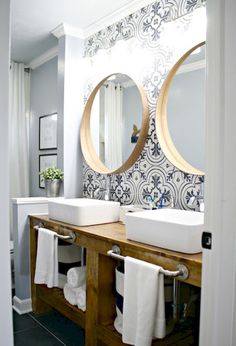 a bathroom with two sinks, mirrors and towels on the rack in front of it