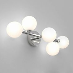 three lights that are on the side of a wall mounted light fixture in a room