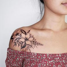 a woman with a flower tattoo on her upper arm and shoulder is looking at the camera