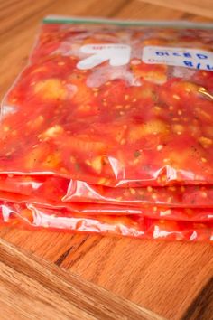 three bags of food sitting on top of a wooden cutting board