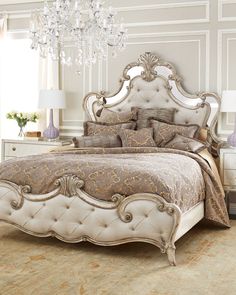 a bedroom with a bed, chandelier and two lamps on the nightstands