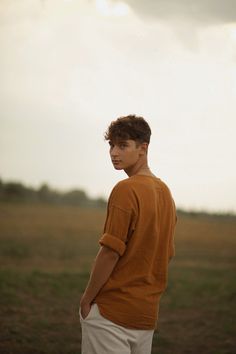 a young man standing in an open field