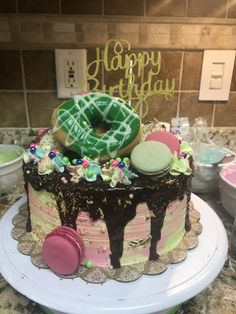 a birthday cake with chocolate frosting and sprinkles on it, sitting on a counter