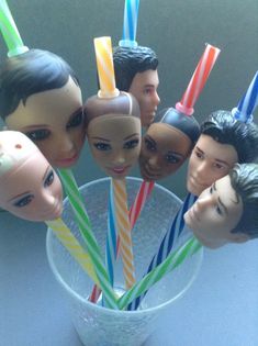 there are many toy heads with candles in the cup