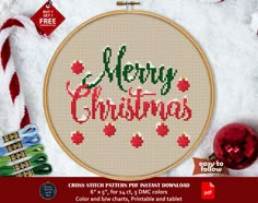 a cross stitch pattern with the words merry christmas in red and green on it, surrounded by holiday decorations