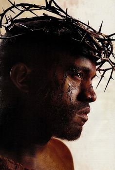 a man wearing a crown of thorns on top of his head with dirt all over his face