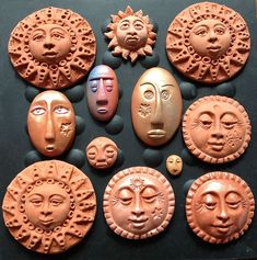 nine clay faces are shown on a black surface