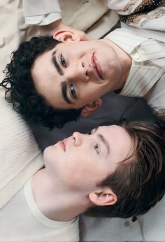 two young men laying on the ground looking up