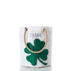 a white bag with a green clover on the front and rope handles to handle it