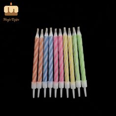 six multicolored candles are lined up in a row on a black background with the words magic eight written below them