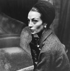 black and white photograph of a woman wearing a turban with gloves on her head