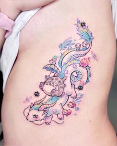 a woman's stomach with an artistic tattoo design on the side of her belly